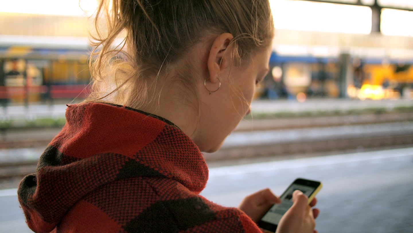 Professional woman checking a smartphone while managing customer follow-up and sales activity